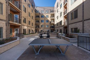 A patio with a table surrounded by apartment buildings.